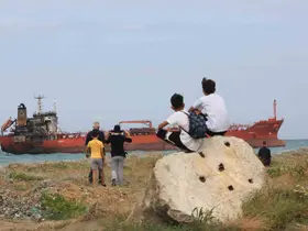 Dron saldırısı sonrası karaya oturan gemi ilgi odağı oldu
