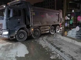 Hafriyat kamyonunun patlayan lastiği iş yerinin camlarını kırdı
