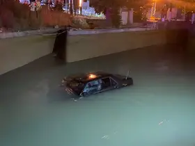 Kanala düşen otomobil, vinçle aracın üzerine inen şahsın halat takmasıyla kurtarıldı
