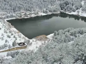 Karla kaplı orman içerisindeki gölet, kış manzarasıyla mest ediyor
