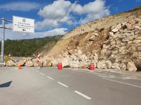 Kumluca-Kemer karayolunda toprak kayması, heyelanı önlemek için örülen duvardaki kayalar yola saçıldı
