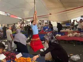 Kuvvetli rüzgarda pazarcı branda direğini bırakmadı, metrelerce havaya yükseldi
