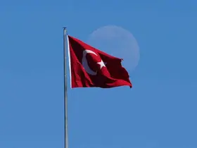Mavi gökyüzünde Türk bayrağı ve ay manzarası

