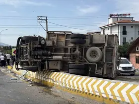 Rampadan inerken kontrolden çıkan kamyon bariyere çarpıp yan yattı
