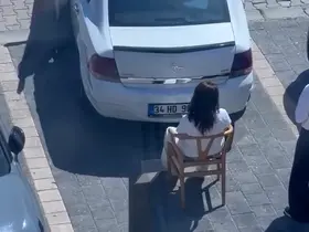 Sandalyeye oturarak kadın sürücünün park etmesini engelledi
