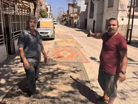 Tozdan bunalan mahalleli çareyi sokağa halı sermekte buldu
