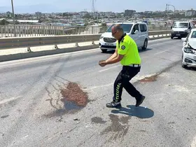 Trafik güvenliğini sağlamak amacıyla yağ dökülen yola avuçlarıyla kum taşıyan polis takdir topladı
