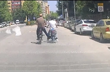 Bisiklet ile motosikleti ayağı ile iterek ilerletti 