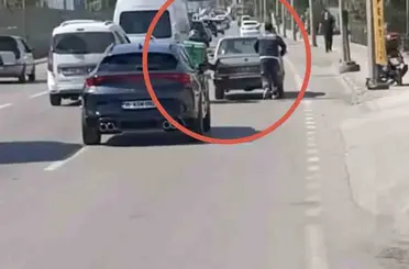 Bursa’da motokuryeden arızalanan otomobili itmek için ilginç yöntem
