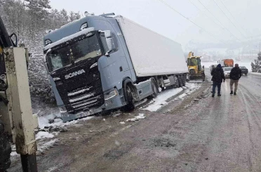 Karlı yolda, tır şarampole devrildi 