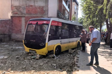 Minibüs, iş yerine çarptıktan sonra boş arsaya uçtu 