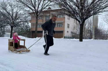 Torununu kızakla çekerek antrenman yapıyor 