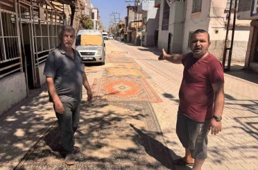 Tozdan bunalan mahalleli çareyi sokağa halı sermekte buldu 