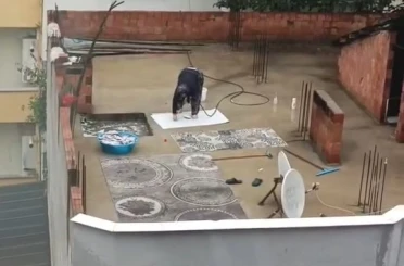 Yağmurlu havada çatıda halı yıkadı, görenler şaştı kaldı 