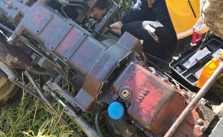 Devrilen traktörün altında kalan 3 kişi yaralandı
