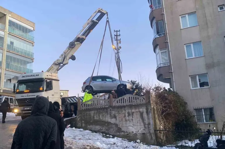 Buzlanan yolda kayan otomobil apartmanın bahçesine düştü
