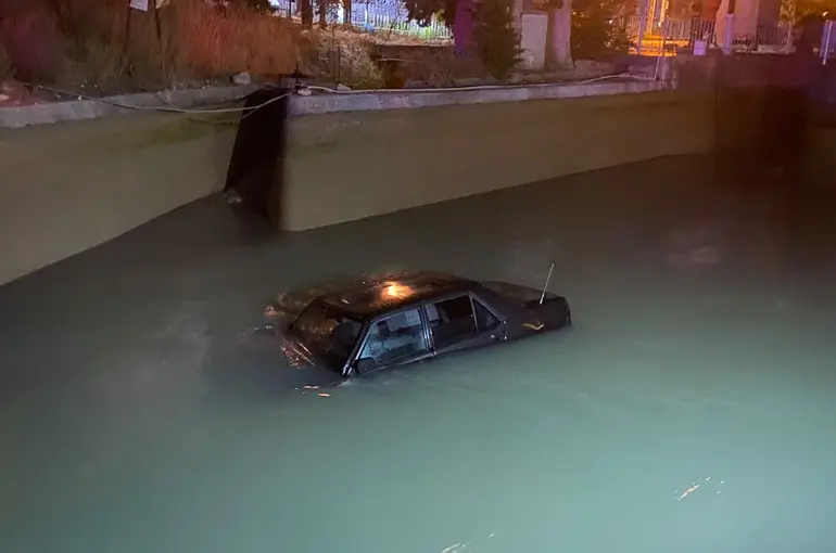 Kanala düşen otomobil, vinçle aracın üzerine inen şahsın halat takmasıyla kurtarıldı
