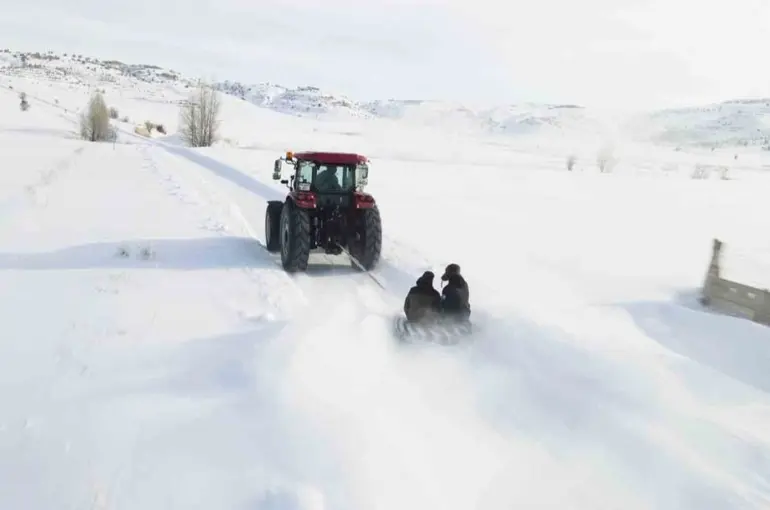 Kar yağışını fırsata çevirdiler, traktörün arkasında kayarak eğlendiler
