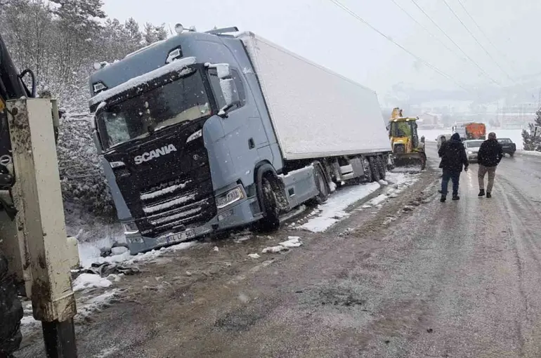 Karlı yolda, tır şarampole devrildi
