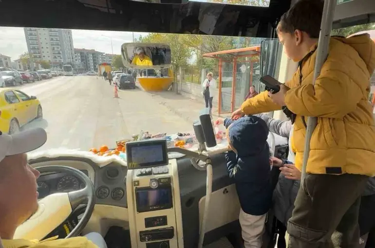 Şoför minibüse binen yolcularına meyve ve şekerleme ikram ediyor
