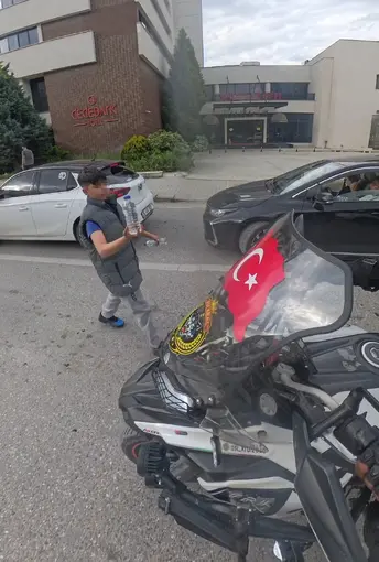 Su satan çocuk, camında Türk bayrağı olan motosikletliye su hediye etmek istedi
