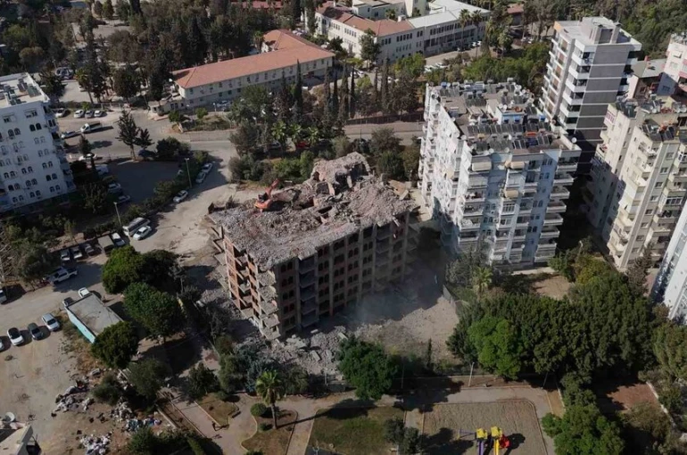 Adana’da yaklaşık 33 yıl önce inşaatına başlanan 11 katlı bina, damına iş makinesi çıkartılarak yıkılıyor