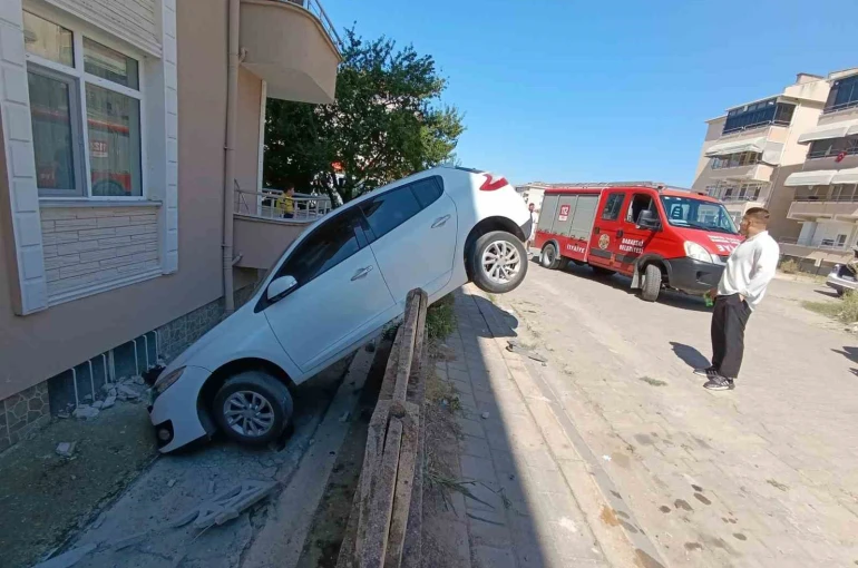 Otomobil bahçe duvarına asılı kaldı