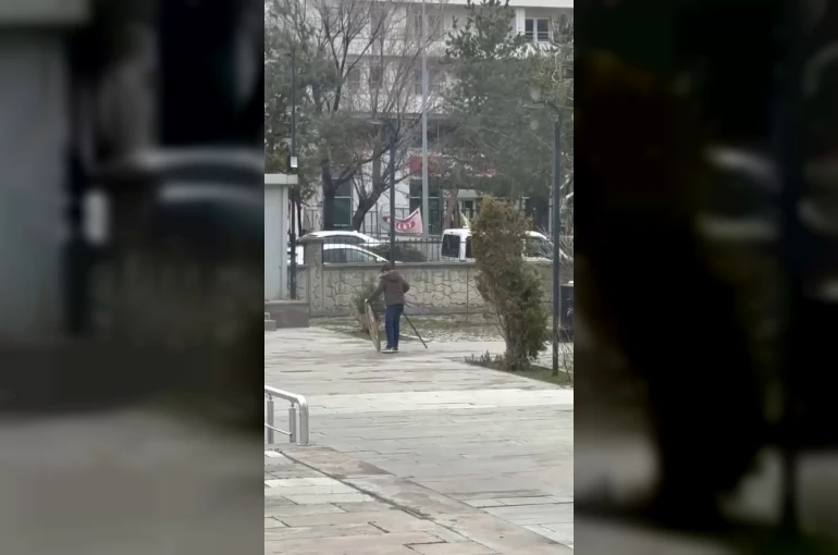 Rüzgârın devirdiği polis çelengini genç yerine koydu 
