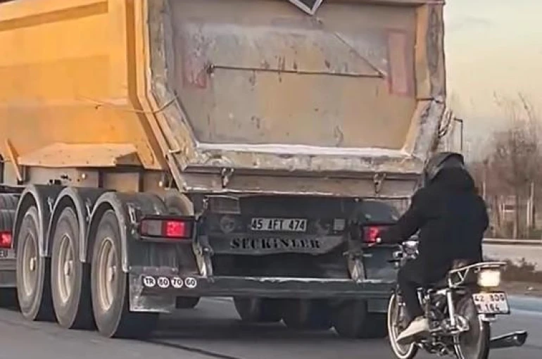 Seyir halindeki tırın peşinde motosikletli tehlikeli yolculuk